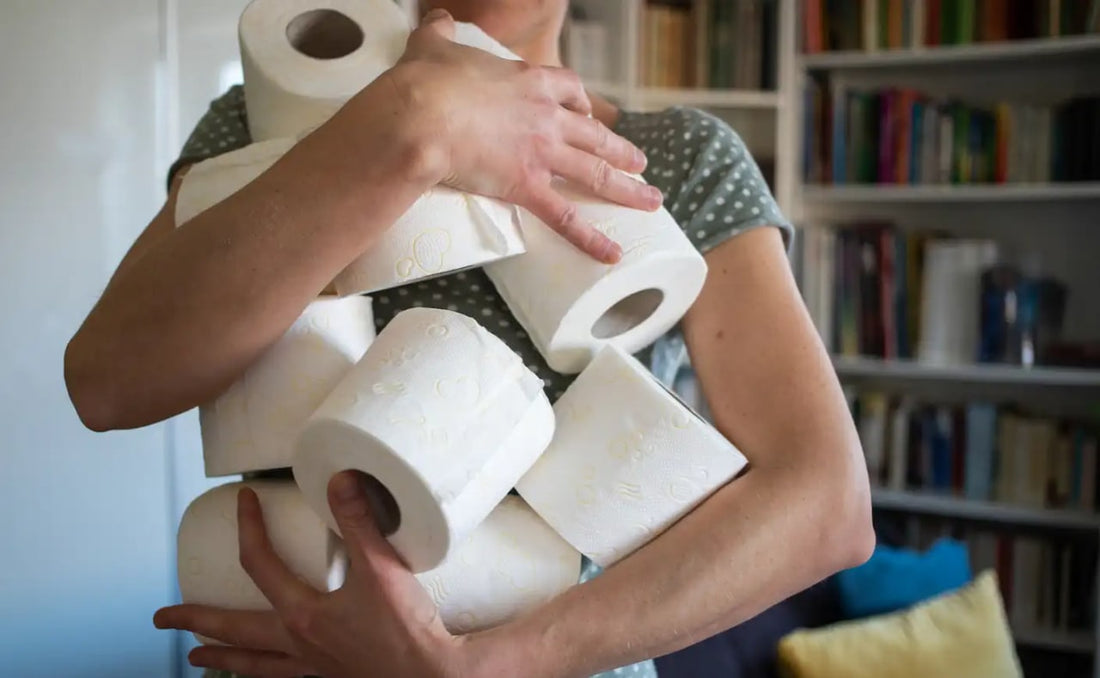women holding large amount of toilet paper in her arms